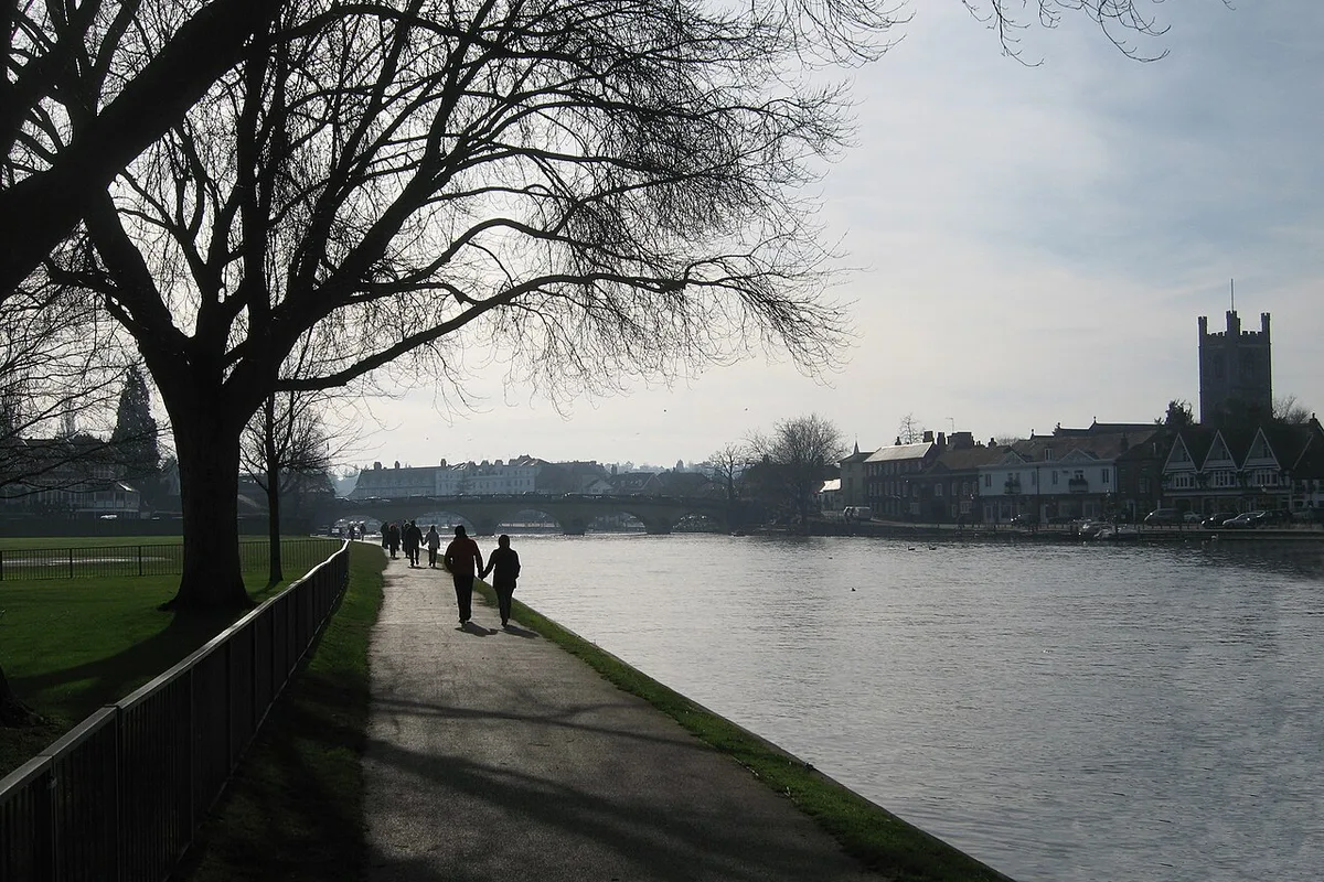 The Thames Path towpath beside the River Thames at Henley-on-Thames, with rowers training on the Regatta reach